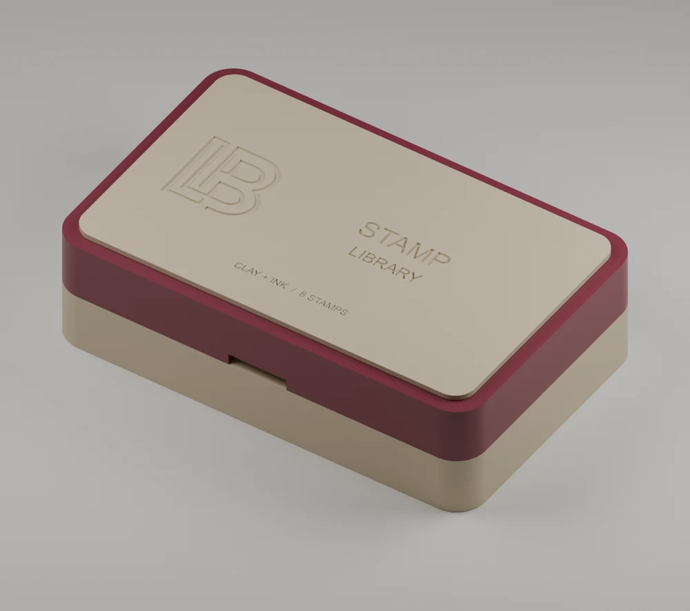 Gesloten stempeldoosje in zandkleur en bordeaux, met LB-monogram en Stamp Library op het deksel
