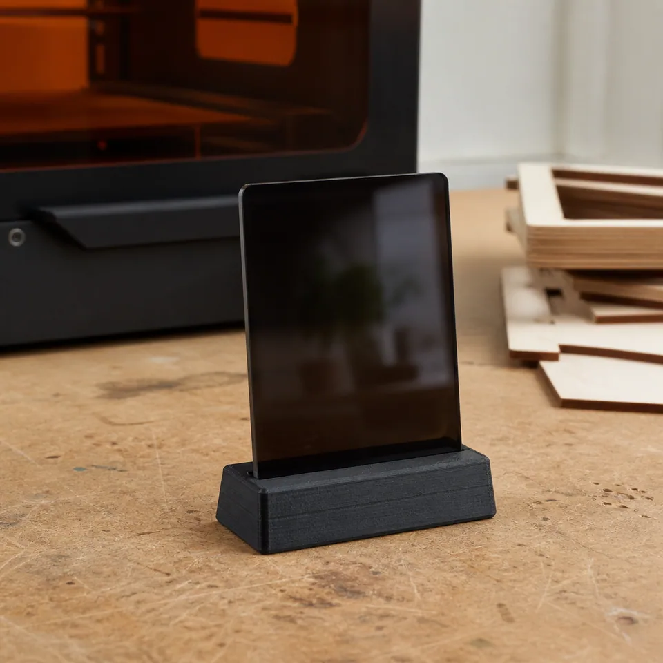 Lasergesneden acrylbord in een 3D-geprinte voet op een echte werkbank